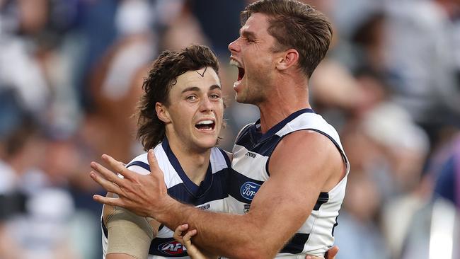 Jordan Clark, Tom Hawkins and the Cats roar after the late sealer. Picture: Michael Klein