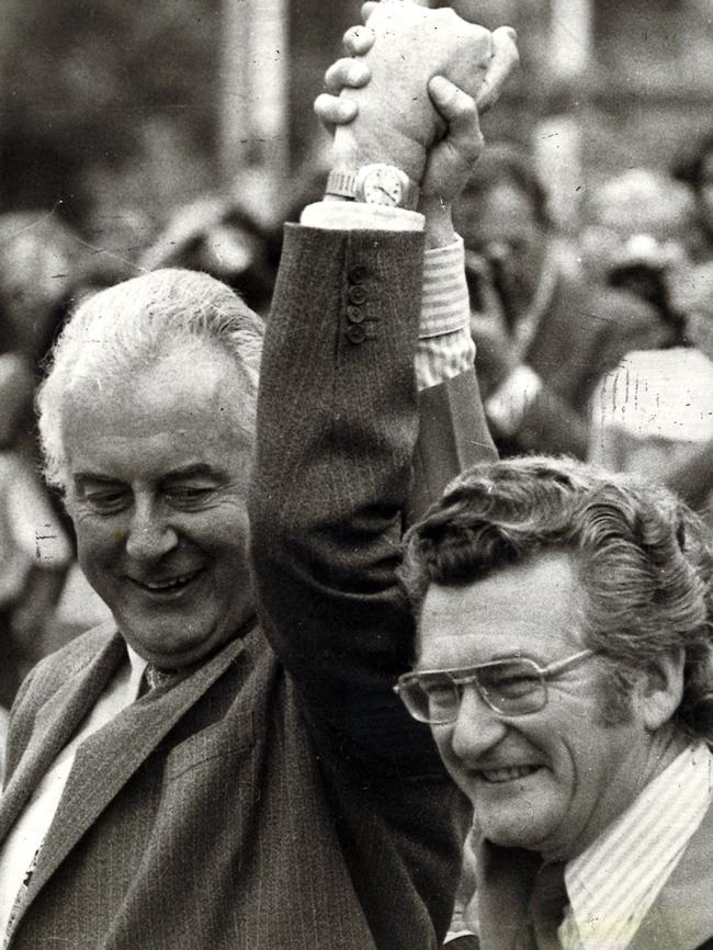 Gough Whitlam and Bob Hawke clasp hands in salute at ALP rally in 1975.