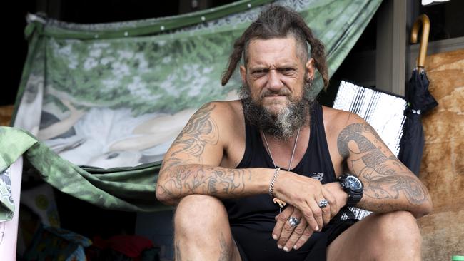 Joshua Winston-Williams has been living outside a shopfront in Ipswich’s East St near a sign spruiking the government’s achievements on housing. Picture: Richard Walker