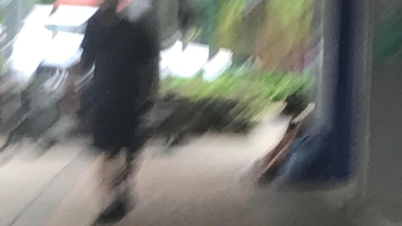 A homeless man sits with his head lowered in Bundaberg’s CBD as locals pass by. The city is in the grips of both an unprecedented boom and a pandemic of homelessness and poverty.