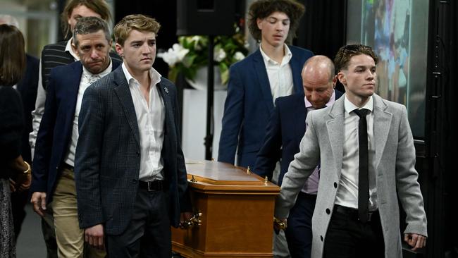 Ben and Will Price and their father Simon Price lead the pall bearers. Picture Mark Brake