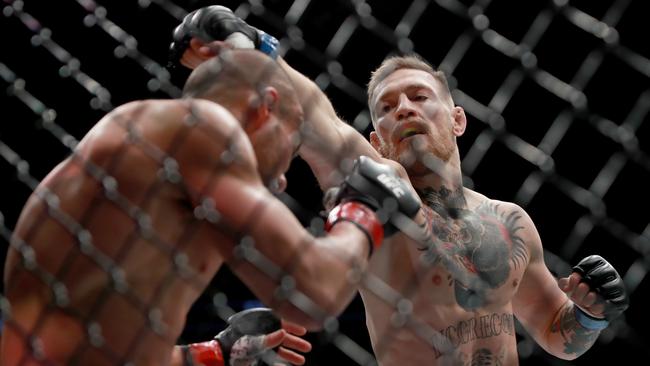Conor McGregor punches Eddie Alvarez in their UFC lightweight championship fight.
