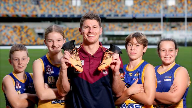 Dayne Zorko, with kids L to R, William Burns 12yrs, Georgia Burns 13yrs, Ethan Duke 13yrs, Sophie Duke 12yrs, from the Jindalee Jags, the Jags footy ground flooded and Lions players are auctioning off their boots for flood recovery, Tuesday 29th March 2022 - Photo Steve Pohlner