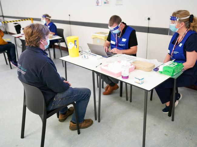 A man gives his details to medical workers at a vaccination centre in the UK. Picture: Getty Images