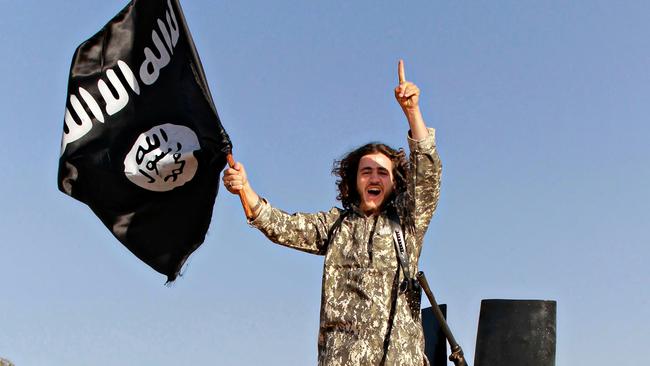 An Islamic State of Iraq and the Levant fighter waves a Black flag during a military parade in Raqqa in 2014. Picture: AFP.