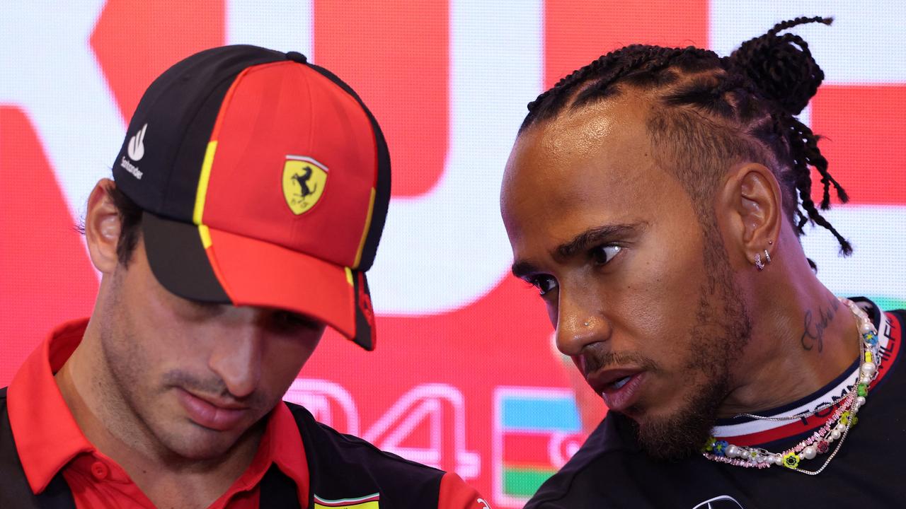 Spanish driver Carlos Sainz Jr (L) speaks with Mercedes' British driver Lewis Hamilton. (Photo by Giuseppe CACACE / AFP)