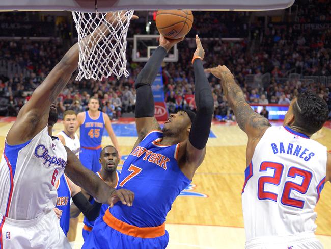 New York Knicks forward Carmelo Anthony, centre, shoots as Los Angeles Clippers centre DeAndre Jordan, left, and forward Matt Barnes defend.