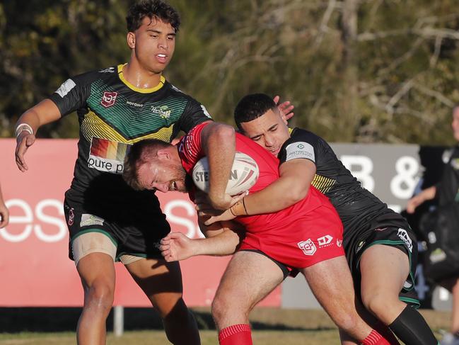 Ken Allison of Currumbin Eagles is tackled by Epokifoou Polaapau and Campbell Pirihi of Helensvale Hornets during the Rugby League Gold Coast A Grade clash. Photo: Regi Varghese