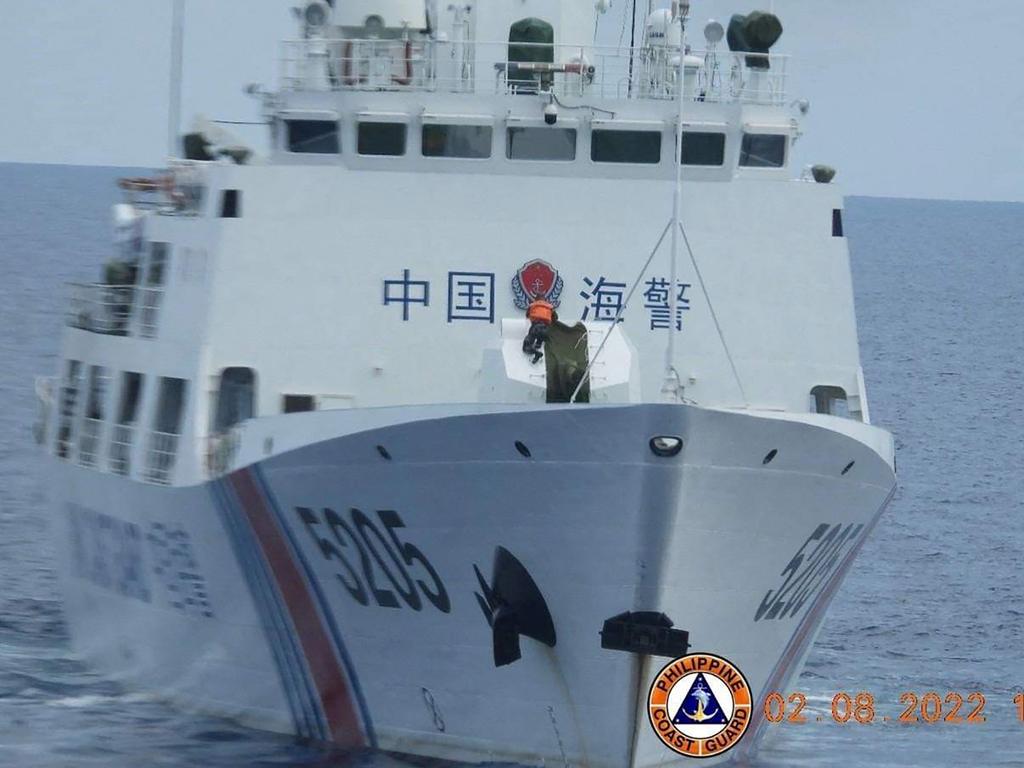 A Chinese Coast Guard sailor removing a cover of a ‘70mm naval armament’. Picture: Philippine Coast Guard/AFP