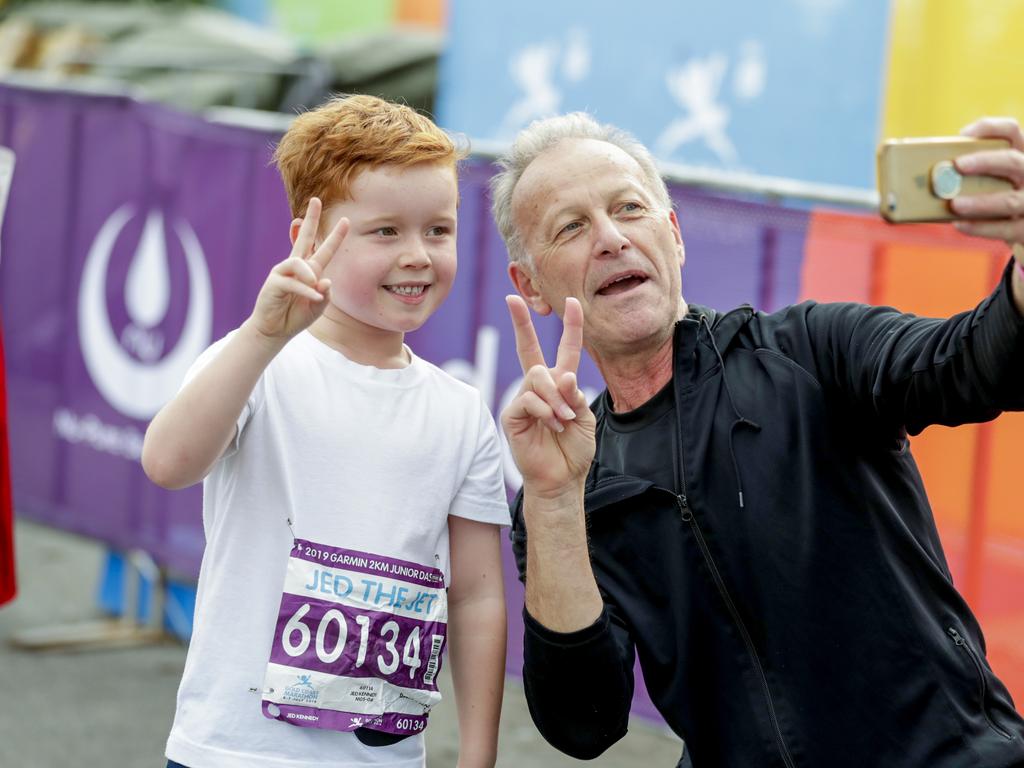 Jed ‘The jet’ Kennedy, 6, with grandfather Rob Ercoli take a photo for posterity at the finish of the Two Kilometre Junior Dash. Picture: Tim Marsden.