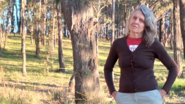 Deb Stevenson in front of some of the trees to be removed to make way for the bypass.