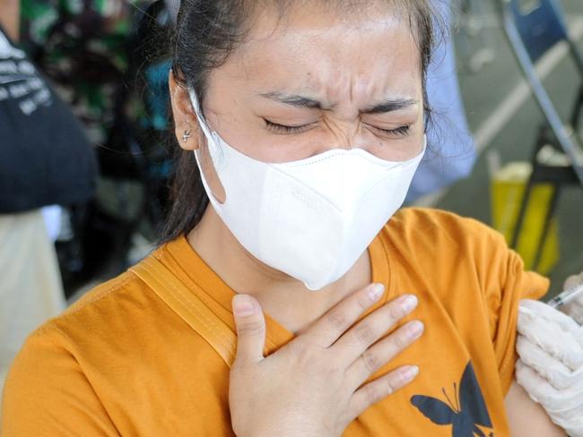 A woman receives the AstraZeneca Covid-19 coronavirus vaccine at a makeshift mass vaccination clinic in Denpasar on Indonesia's resort island of Bali on July 6, 2021, as the Southeast Asian nation battles an unprecedented wave of new infections. (Photo by SONNY TUMBELAKA / AFP)