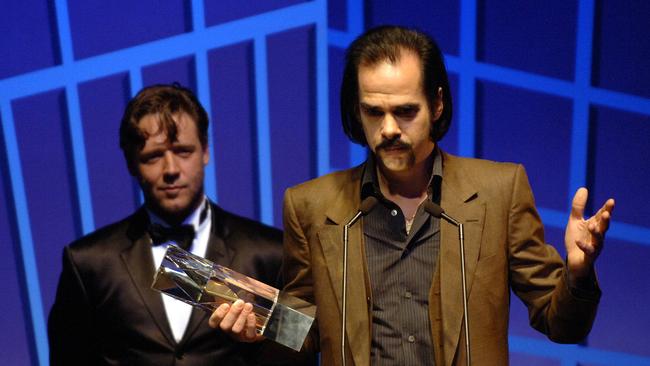 Nick Cave being presented with an award by Russell Crowe.