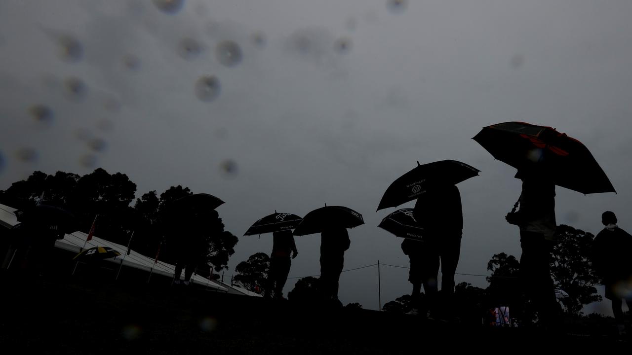 : Spectators shelter from the rain on day three of the Australian Open at Kingston Heath (Photo by Darrian Traynor/Getty Images)