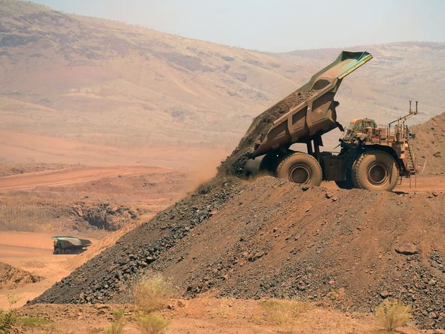 An autonomous haul truck dumps a load of rock in the mine pit at Rio Tinto Group's Gudai-Darri iron ore mine in the Pilbara region of Western Australia, Australia, on Thursday, Oct. 19, 2023. Rio Tinto is preparing for trials of battery-powered locomotives in Australia, where it uses giant autonomous trains — the world’s largest and longest robots — to transport iron ore across the vast Outback. Photographer: Carla Gottgens/Bloomberg