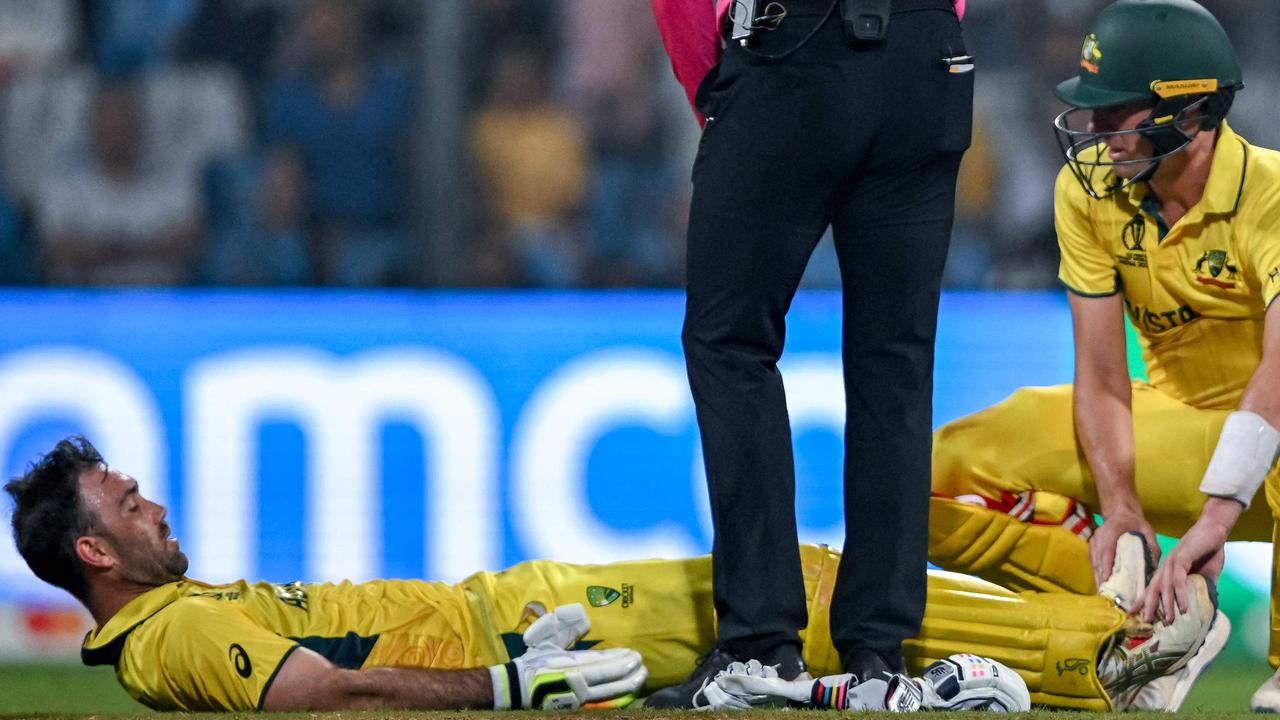 Australia's Glenn Maxwell (left) is helped by his captain Pat Cummins in an attempt to ease the pain of Maxwell’s cramps during the match. Picture: AFP