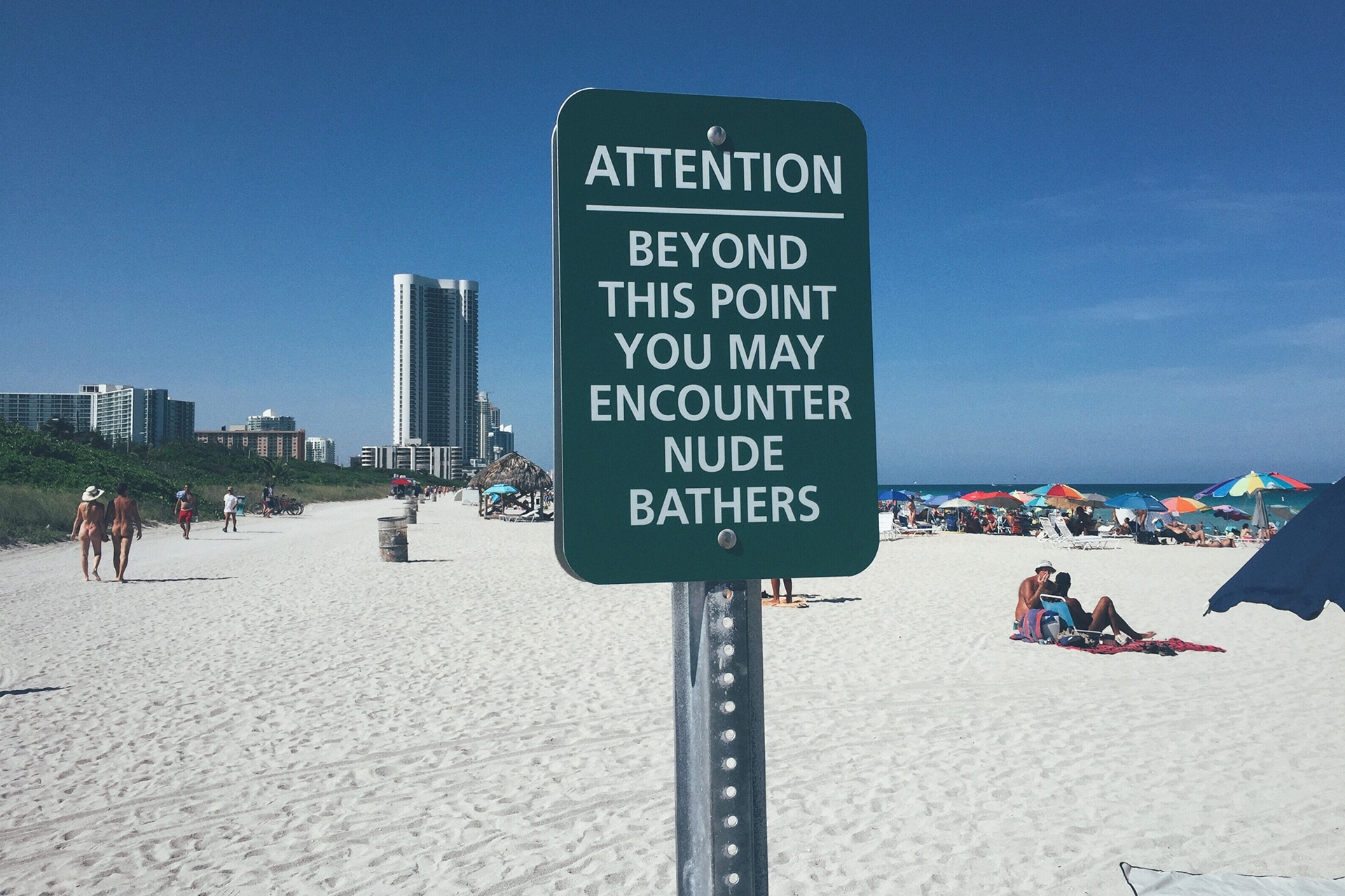 Hundreds of nudist people running into the sea naked