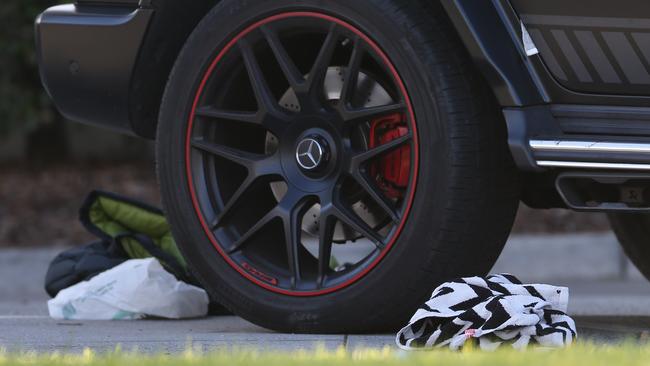 CLothing and belongings lie next to the ex-bikie’s Mercedes. Picture: Brendan Beckett