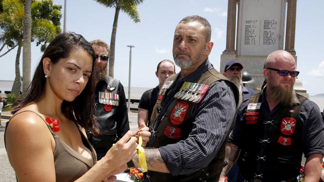 Ashleigh Boileau whose former partner, soldier Bradley Carr committed suicide places a yellow band on war veteran Ray Rosendale at the Remembrance Day commemorations at the Cairns Cenotaph. She is calling for a Royal Commission in to suicides of Military personnel . PICTURE: ANNA ROGERS