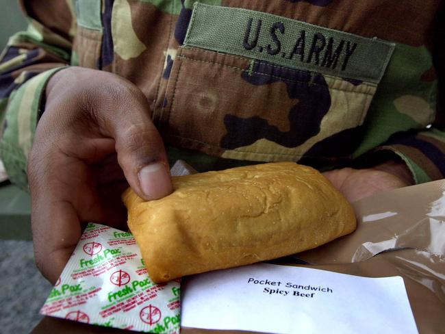 30/09/2002. U.S. Army Pvt. Kemoathe Green of Saginaw, Mich., holds up a "spicy beef" pocket sandwich, which is more than two years old, while conducting a tour of the long lasting food technology at the U.S. Army Soldier System Center in Natick, Mass. The MRE, acronym for meal ready to eat, has been designed to last three years in the field. (AP Photo/Charles Krupa)