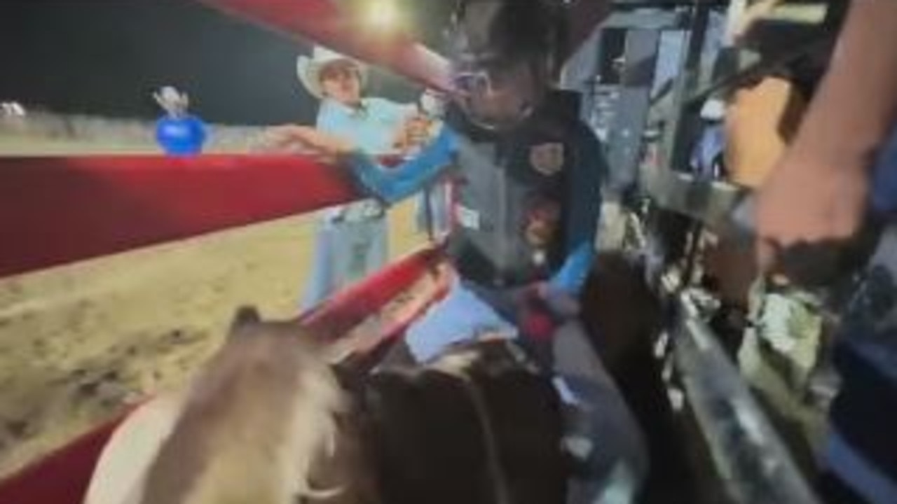 India, 12, bravely waits in the bucking chute, sitting on the bull.
