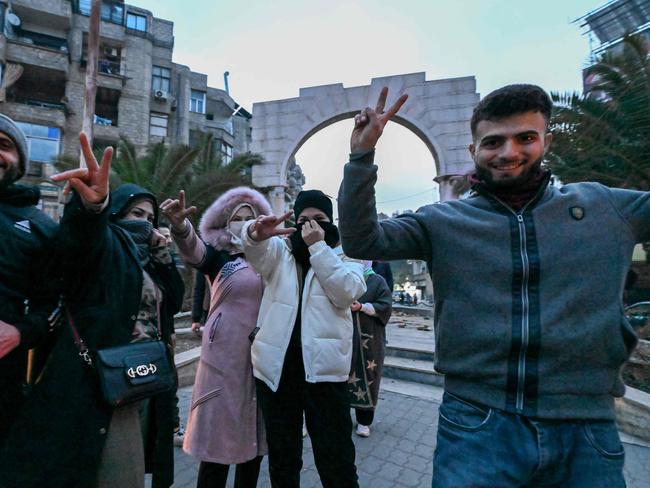 Local residents cheer as the gather on a street in the Damascus suburb of Jaramana on December 8. Syrian rebels said President Bashar al-Assad had fled the country, calling on citizens abroad to return to a "free Syria" and saying that Damascus was free of the "tyrant". Picture: Louai Beshara/AFP