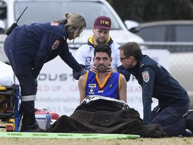 Tyabb captain Ethan Rahilly is attended to by paramedics on Saturday. Picture: Andy Brownbill