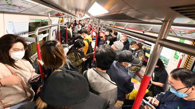 People travel on a crowded underground train in Hong Kong on February 18, 2022, as the city faces its worst Covid-19 outbreak since the start of the pandemic. (Photo by Peter PARKS / AFP)