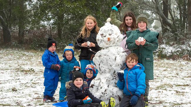 Mt Macedon residents Ella, Harry, Tom, Bella, Lachlan, Callan, Beckett and Charlie built a snowman as the frosty conditions hit. Picture: Jay Town.