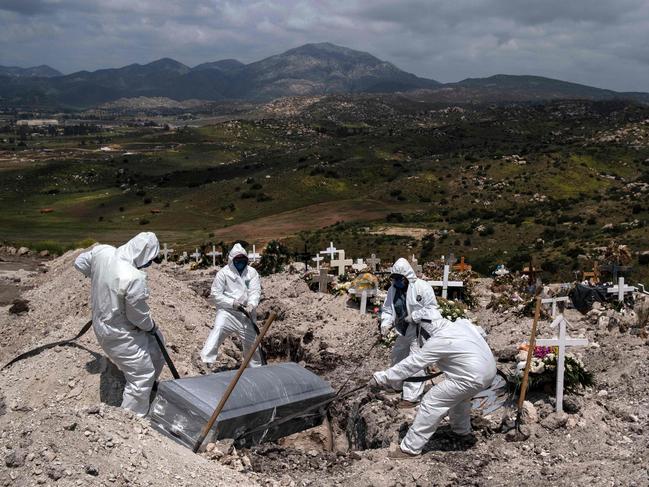 Cemetery workers bury an unclaimed coronavirus victim in Tijuana, Mexico. Picture: AFP