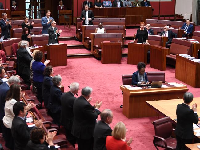 Senators from both sides join in applauding Attorney-General George Brandis for criticising One Nation Senator Pauline Hanson for wearing a burqa during Senate Question Time. Picture: AAP