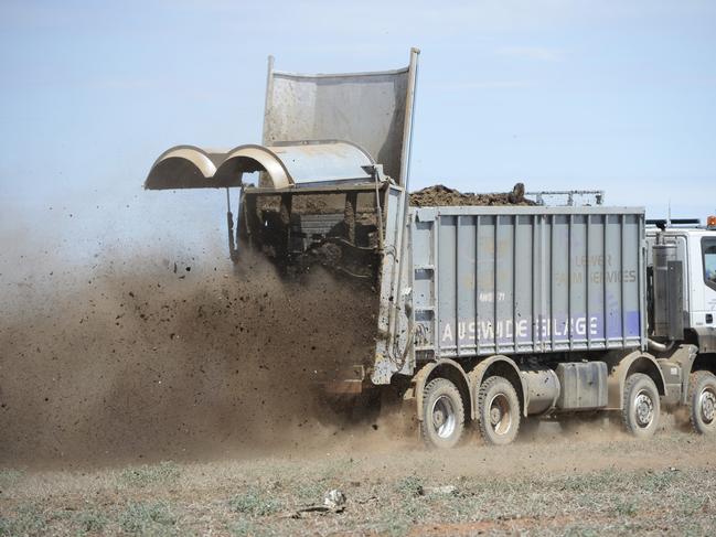 MACHINE: SPREADER Muck Spreader Truck. Steve Lewer & brother Dave from Winchelsea, Lewer Farm Services, contractors working at Blighty, NSW. spreading cow manure.the truck is a 8 wheel drive 480 hp Iveco Astra. 30m2 Fliegl ejector Bin made in Gremany.doubles as a spreader & silage truck