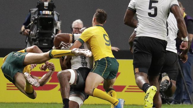 Australia's Reece Hodge, left, goes flying after his contact with Fiji’s Peceli Yato on Saturday. Picture: AP