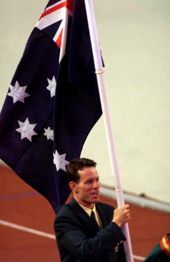 Kieren Perkins carries flag in Kuala Lumpur. Picture: Phil Hillyard