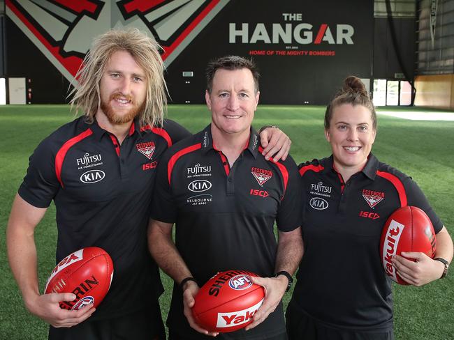 Dyson Heppell, coach John Worsfold and Lauren Morecroft of the Bombers pose at "The Hangar"