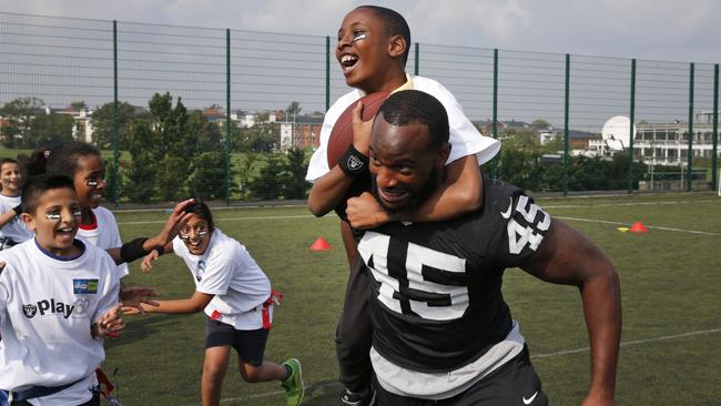 Oakland Raiders Marcel Reece plays football with children during an event in Guildford, England.