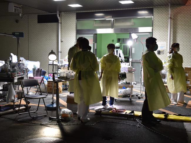 Medical staff prepare to evacuate patients from the hospital in Kumamoto City over fears it could collapse as a wave of aftershocks shake the area.