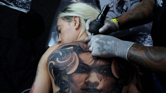 A tattoo artist works during the 14th Expotattoo Colombia Fair in Medellin, Colombia, on May 26, 2024. (Photo by JAIME SALDARRIAGA / AFP)