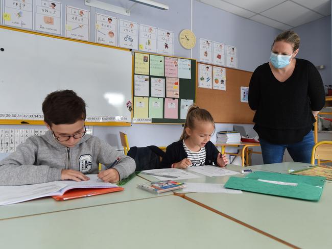 A teacher wearing a protective face mask gives a lesson in France where schools are also set to reopen from May 11 Picture: AFP