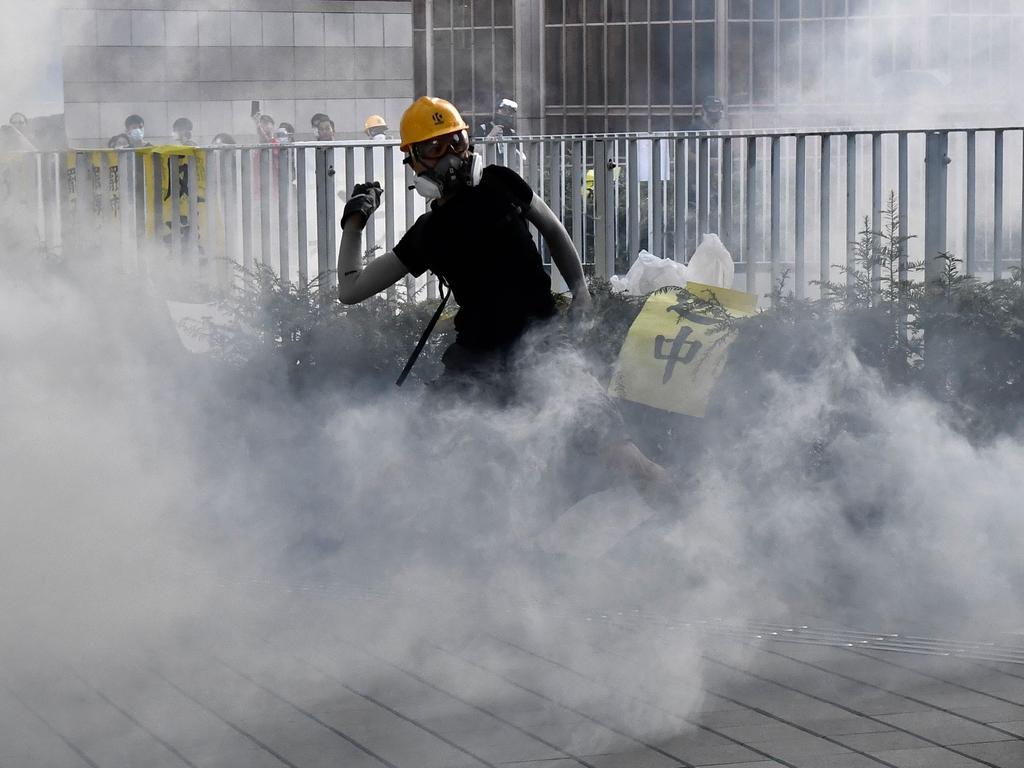 A protester throws back teargas fired by the police during a strike in Hong Kong. Picture: AFP