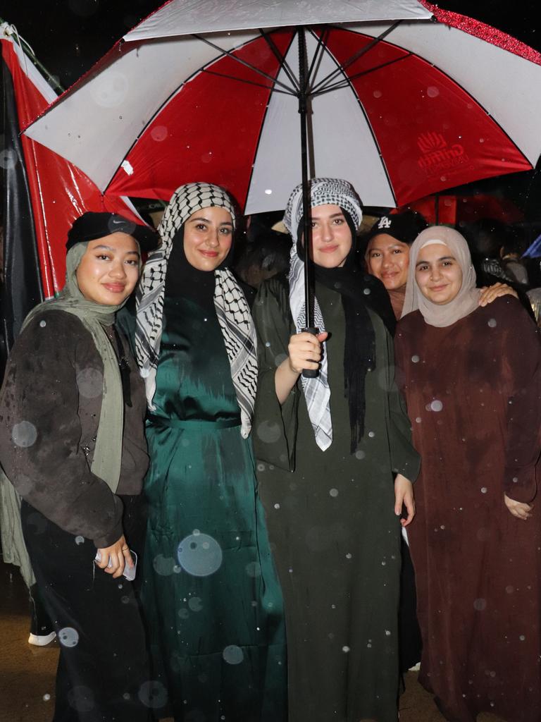 Protesters gathered at Surfers Paradise Esplanade despite torrential rain to call for an immediate ceasefire of bombing in the Gaza Strip. Picture: Amaani Siddeek