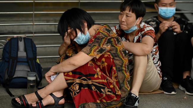 A worried property owner cries as she and other people gather at the Evergrande headquarters in Shenzhen. Picture: AFP)