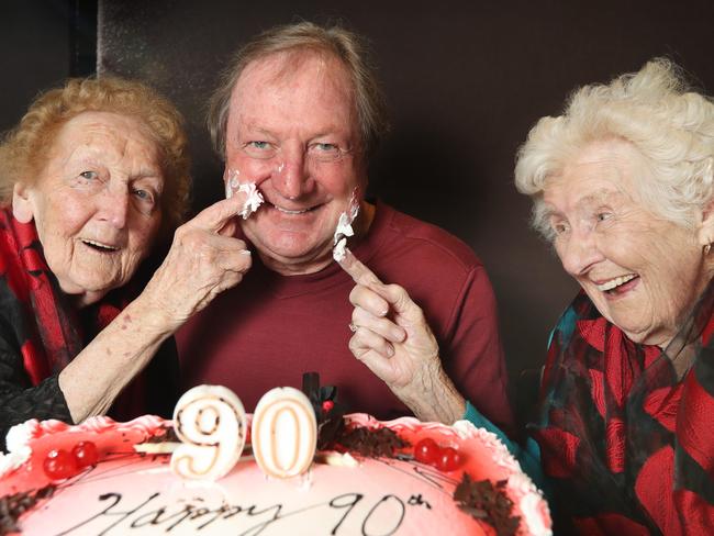 Kevin Sheedy surprised a couple of Essendon's biggest fans by turning up at their 90th birthday celebrations. Essendon life member Merna Slattery [left] and her friend Alwin Chestnut [right] have both been Bombers members for more than 60 years. Picture: Alex Coppel