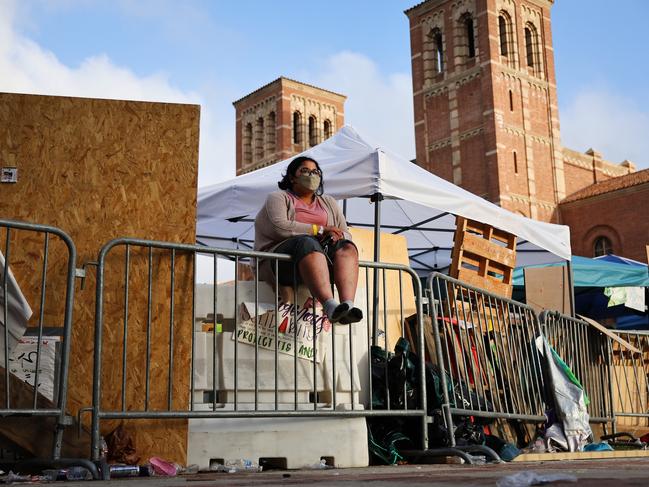 A protester sits beside barricades at a pro-Palestinian encampment on the UCLA campus in Los Angeles. The camp was attacked by counter-protesters overnight, leaving some demonstrators injured. Declared “unlawful” by the university, the violence has prompted the cancellation of classes. Picture: Mario Tama/Getty Images