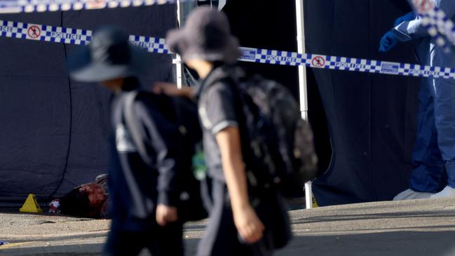 Students walk past David Stemler’s body as forensics police set up the crime scene in Canterbury. Picture: NCA NewsWire