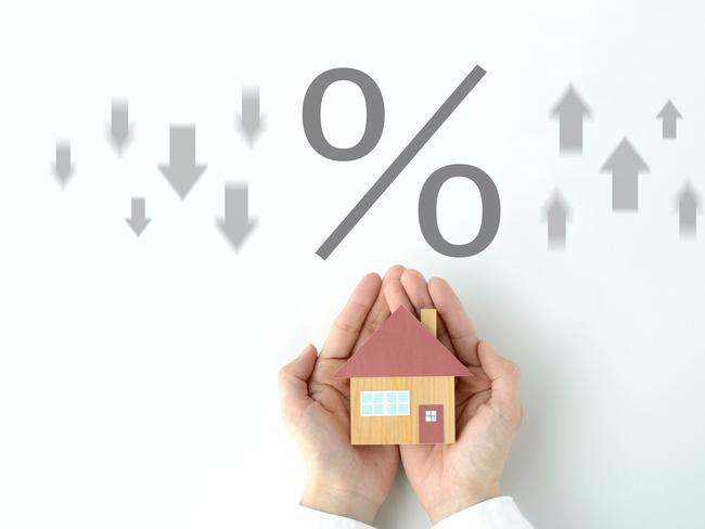 House object covered by human's hands and percentage sign with upward and downward arrows. home loan interest rate mortgage generic