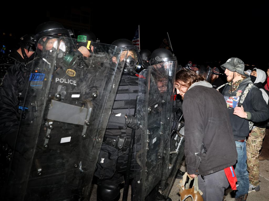 Police officers in riot gear confront protesters who are gathering at the U.S. Capitol Building. Picture: AFP