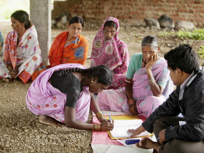 A local woman signs a register to receive a loan during a meeting organized by SKS Microfinance Ltd. in Sadasivpet, India, on Friday, Aug. 6, 2010. SKS provides loans from $22 to $260 each for women raising cows or opening a village tea stall in a nation where 828 million people live on less than $2 a day. Photographer: Adeel Halim/Bloomberg