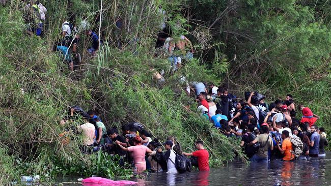 Migrant people cross through the banks of the Rio Grande to the US on Tuesday. Picture: AFP