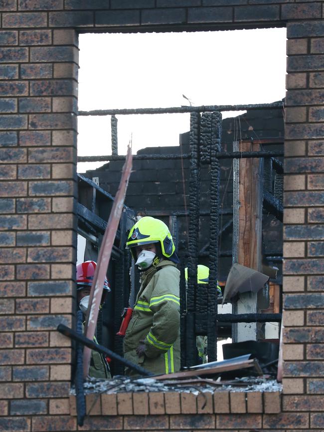 Police and firefighters examine the house. Picture: David Swift